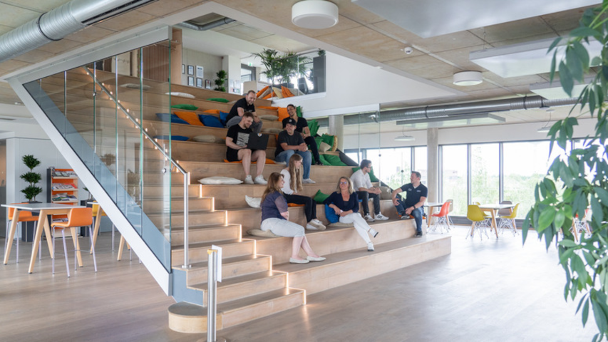 Mitarbeitende der abat AG auf einer Sitztreppe im Büro